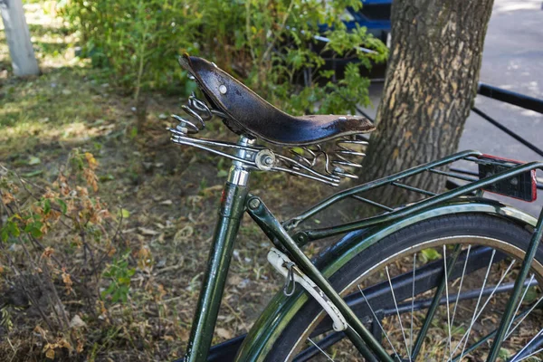 retro leather brown bicycle seat, old-fashioned vintage leather bicycle saddle with metal spring.