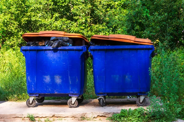 street garbage cans, overflowing garbage from large garbage cans on wheels for garbage, recycling and garden waste.