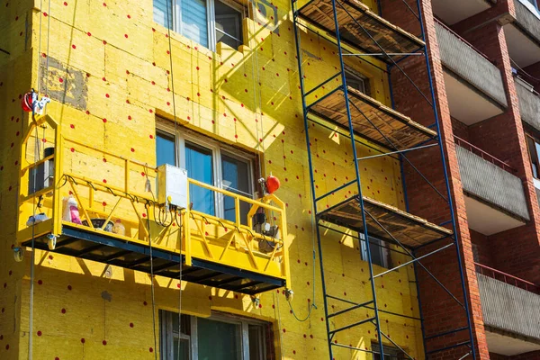 Insulation of the walls of a multi-storey building, construction of a multi-storey building. Thermal insulation of the exterior walls of the house. Thermal insulation materials, mats, plates. The cradle of the lift.