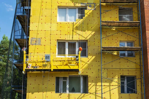 Insulation of the walls of a multi-storey building, construction of a multi-storey building. Thermal insulation of the exterior walls of the house. Thermal insulation materials. The cradle of the lift.