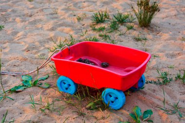 Oyuncak renkli çocuk arabası ve kumların üzerinde koniler..