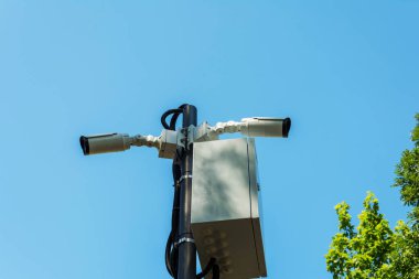 Güvenlik kameraları ve halka açık bir yerde bir direğe kurulmuş bir kablosuz ağ istasyonu. Gözetleme ve güvenlik teknolojileri. Şehrin sokaklarında güvenlik ekipmanları var. Kamu mahremiyeti sorunu.