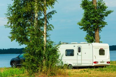 Gölün arka planında karavan, turizm, seyahat, açık hava eğlencesi, aktif yaşam tarzı, aile tatili seyahati, karavan araba tatili. Güzel Doğa