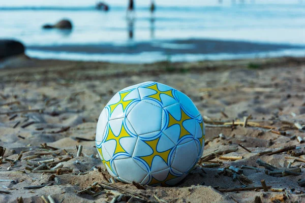 Top plajın kumsalında güneşli bir günde, yaz tatilinde, voleybolda, futbolda yatıyor..