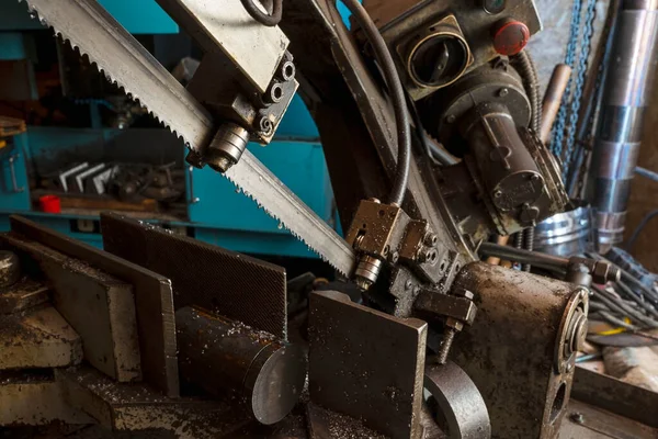 车间里的金属带锯子用液体制冷剂割断一根金属棒 机器的齿轮刀片 — 图库照片