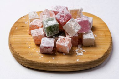 Lezzetli, renkli lükum, beyaz arka planda pudra şekerli Türk lokması. Lezzetli doğal lezzet, tatlı.