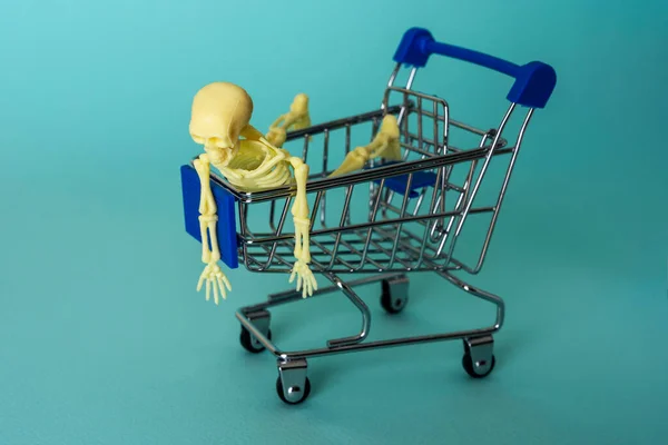 Composição Minimalista Criativa Esqueleto Montado Carrinho Supermercado Fundo Turquesa Crânio — Fotografia de Stock
