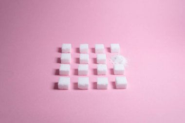 Beyaz şeker küpleri pembe arka plan kompozisyonu. Minimum gıda konsepti. Sağlıksız yaşam tarzı fikri.