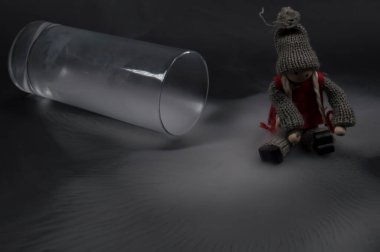 Karanlık bir arka planda dumanla dolu bir bardak, tahta oyuncak küçük bir kız patenle soyut bir kompozisyon. Asgari soyut kompozisyon, modern. 