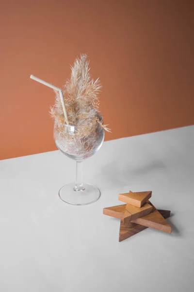 Pampas otlu kokteyli bir bardakta pampa sapından yapılmış pipetle. Minimum soyut kompozisyon arka planı. Japon iç mimari fikri. Serinletici fikir. Seçici odaklı iki renk arkaplanı.