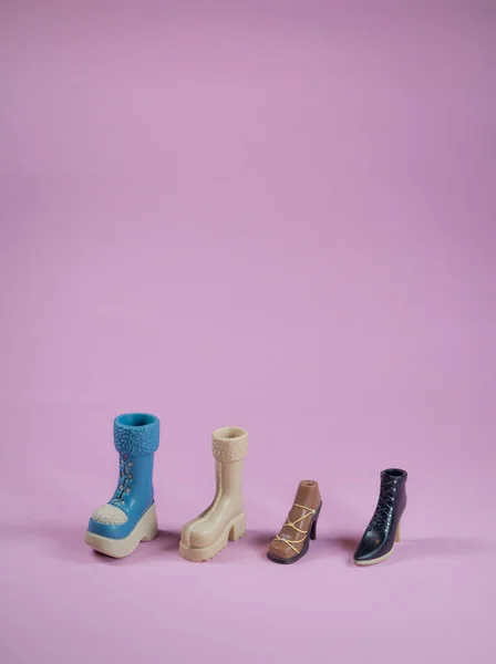 Yumuşak pembe arka planda çeşitli tarz bebek ayakkabıları. Asgari alışveriş ve moda konsepti. Kopyalama alanı ile.