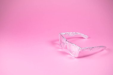 Pembe arka planda alüminyum folyoya sarılı olan güneş gözlükleri. Geleceğe yönelik bir bakış. Asgari soyut yaz konsepti. Kopyalama alanı ile.