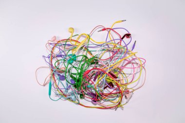 Düz beyaz arka planda duran çok renkli kulaklıklar. Müzik fikri. Asgari soyut parti ve teknoloji konsepti.