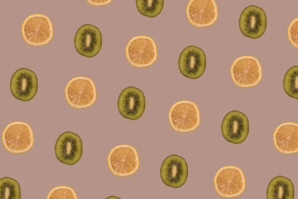 Limon ve kivi dilimleri pastel kahverengi arka planda çoğaldı. Minimum sağlıklı gıda, tropikal meyve ve yaz konsepti.