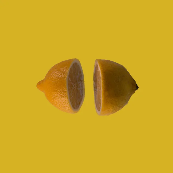两个柠檬半漂浮在淡黄色的正方形背景上 最小热带水果和夏季概念 — 图库照片
