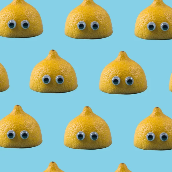 Lemon half with toy eyes multiplied on trendy soft blue background. Minimal abstract summer concept. Summer fun idea.
