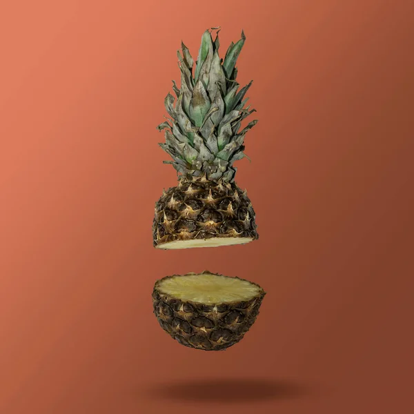 Havada süzülen dilimlenmiş ananas pantonlu paslı arka planda. Asgari yaz konsepti.