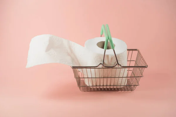 Çelik sepetteki tuvalet kağıdı. Moda pastel arka planda. Hijyenik ve hijyenik malzemeler alıyorum. Salgın bir fikir. Minimum tüketim konsepti. Kopyalama alanı ile.