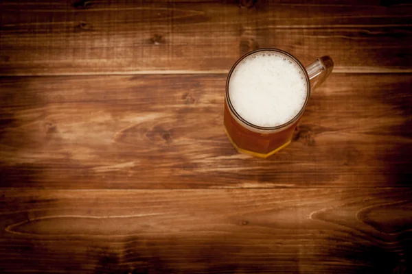 Ένα ποτήρι μπίρα στο παρασκήνιο των ξύλινων σανίδων. — Φωτογραφία Αρχείου
