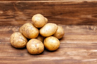 Patates ahşap arka plan üstünde göster