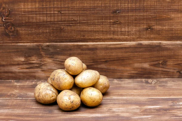 Aardappelen houten achtergrond bovenop bekijken — Stockfoto