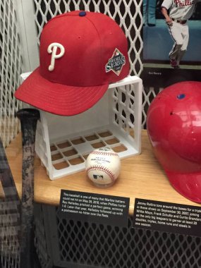 Cooperstown, NY, ABD - 16 Mart 2015: Philadelphia Phillies 'in Ulusal Beyzbol Şöhretler Salonu' nda bulunan ve 2008 Dünya Serisi 'nde giyilen bir şapka ve Kusursuz Oyun' dan bir top dahil olmak üzere çeşitli oyunlar kullanılan ekipman