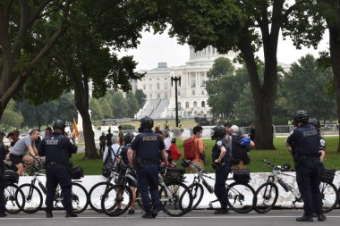 Washington, DC, ABD - 18 Eylül 2021: Beton bariyerlerin yanında bisiklet polisi J6 için Adalet 'in yanında güvenlik bariyeri görevi görüyor