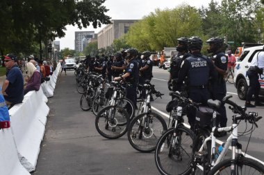 Washington, DC, ABD - 18 Eylül 2021: Beton bariyerlerin yanında bisiklet polisi J6 için Adalet 'in yanında güvenlik bariyeri görevi görüyor