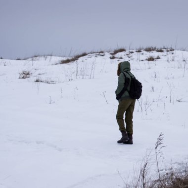 Sıcak giysili gezgin kar kaplı kış konsepti dağının tepesinde yürür ve soğuk mevsimde yürüyüş yapar.