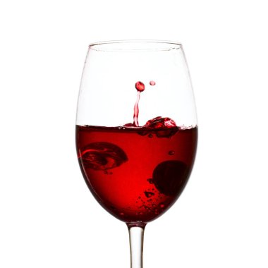 Parlak kırmızı şarap damlası beyaz arka plandaki bir bardaktan süzüldü.