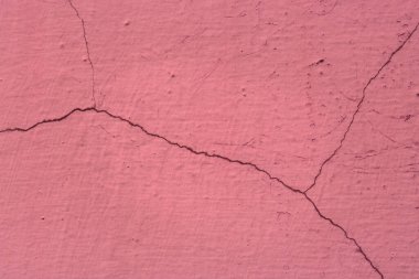 Eski bir duvarın parlak pembe grunge dokusu çatlaklarla kaplı tasarım için arka plan