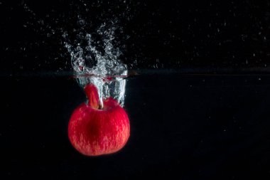 Suya düşen parlak bir elma yiyecek ve meyve kavramının yüzeyine parlak bir sıçrama oluşturdu.