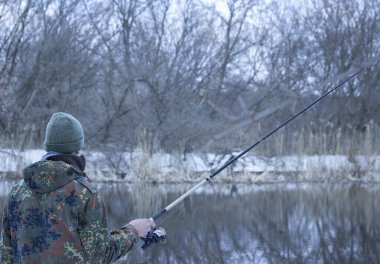 Balıkçı suya bakar ve balık tutma konseptini fırlatmaya hazırlanır.