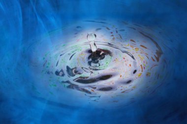 Yüzeyi mavi sisle kaplı çok renkli bir sıvı. Gizemli bir atmosfer.