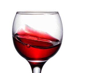 Bardaktaki parlak şarap kırmızı ve beyaz arka planda iştah açıcı üzümlerden yapılan lezzetli bir alkollü içecek.