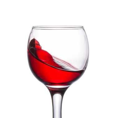 Beyaz arka planda bir kadehte güzel bir şarap damlası. Üzümlerden yapılmış parlak kırmızı bir alkollü içecek.