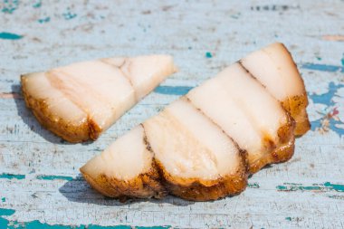 Mavi ahşap arka planda yiyecek ve atıştırmalıklar üzerine iki parça domuz yağı.