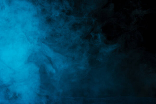 Mysterious and bright cloud of blue steam on a dark background concept of smoking and addiction