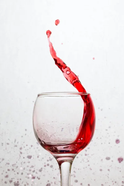 Φωτεινό Κυρτό Ρεύμα Κόκκινου Κρασιού Που Πετά Από Ένα Ποτήρι — Φωτογραφία Αρχείου