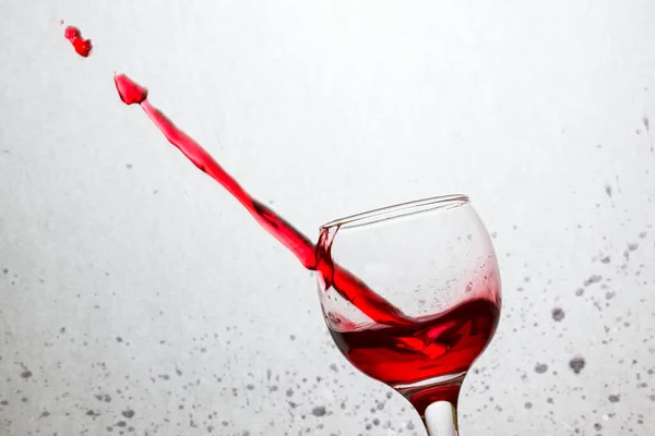 Bicchiere Inclinato Vino Rosso Trafitto Flusso Bevanda Alcolica Uno Sfondo — Foto Stock