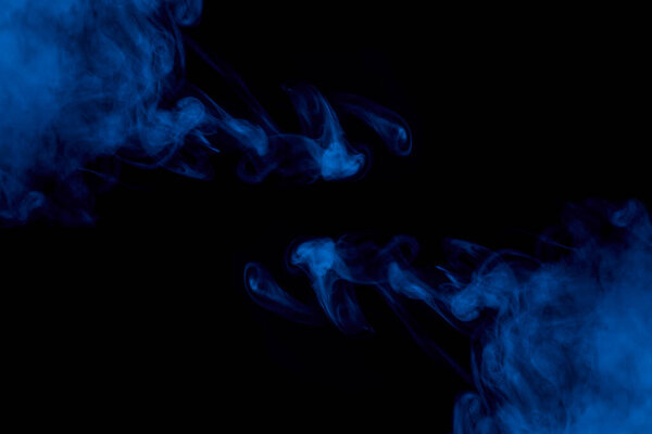 Seductive patterns of blue cigarette vapor mystical and mysterious two clouds on a dark background abstraction for design concept of smoking