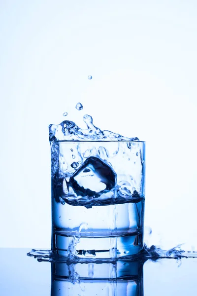 Schöne Spritzer Einem Glas Mit Blauem Wasser Das Ein Stück — Stockfoto