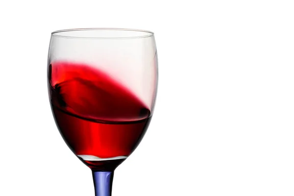 白い背景に青い足のガラスの明るい赤ワイン美しいスプラッシュ — ストック写真