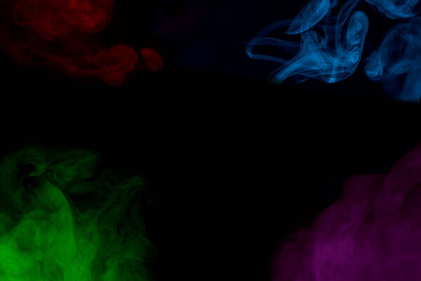 Ghostly clouds of multi-colored cigarette vapor around the edges against a dark background bewitching abstraction for design color concept of smoking
