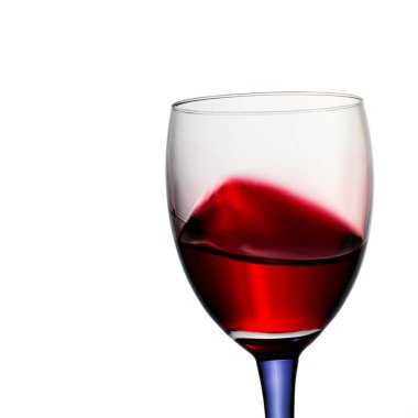 Beyaz arka planda kırmızı şarap bardağa sıçrayan parlak bir alkollü üzüm suyu çok iştah açıcı görünüyor.