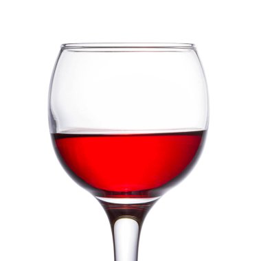 Beyaz arka planda bir bardak parlak kırmızı şarap üzümlerden yapılmış alkollü bir içeceğin yakın plan çekimi.