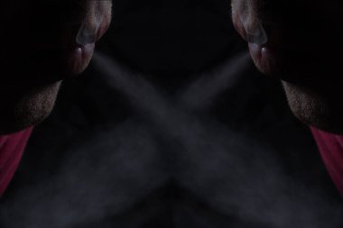 İki nefes, gri sigara buharı, sigara ve bağımlılık kavramını kesiştiren bir desen oluşturuyor.