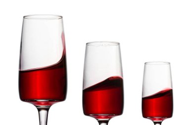 Kırmızı şaraplı üç zarif bardak ve beyaz arka planda farklı yansımalar. Alkol tasarımı için nesneler.