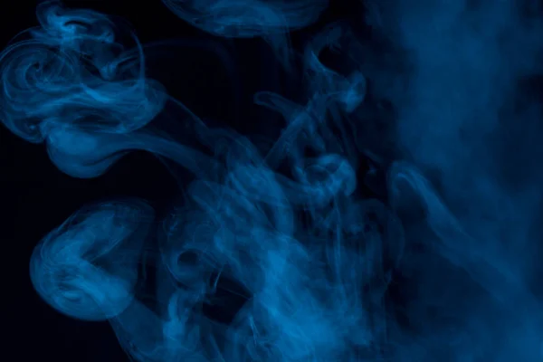 蓝色香烟烟雾形成的神奇图案在黑暗的背景下与迷人的抽象吸烟概念紧密相联 — 图库照片