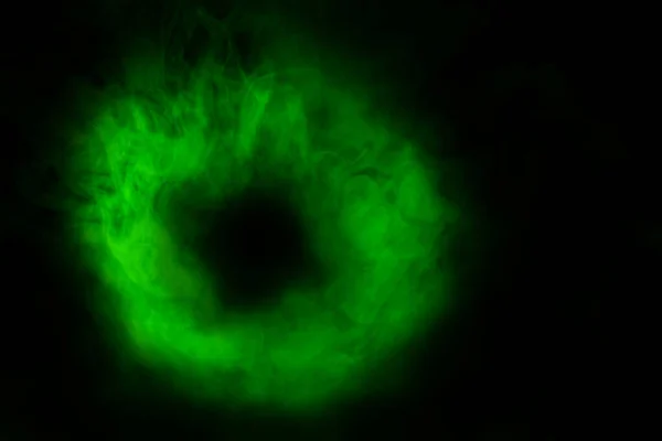 green cigarette vapor ring on black background thick shiny cloud smoking concept abstraction for design